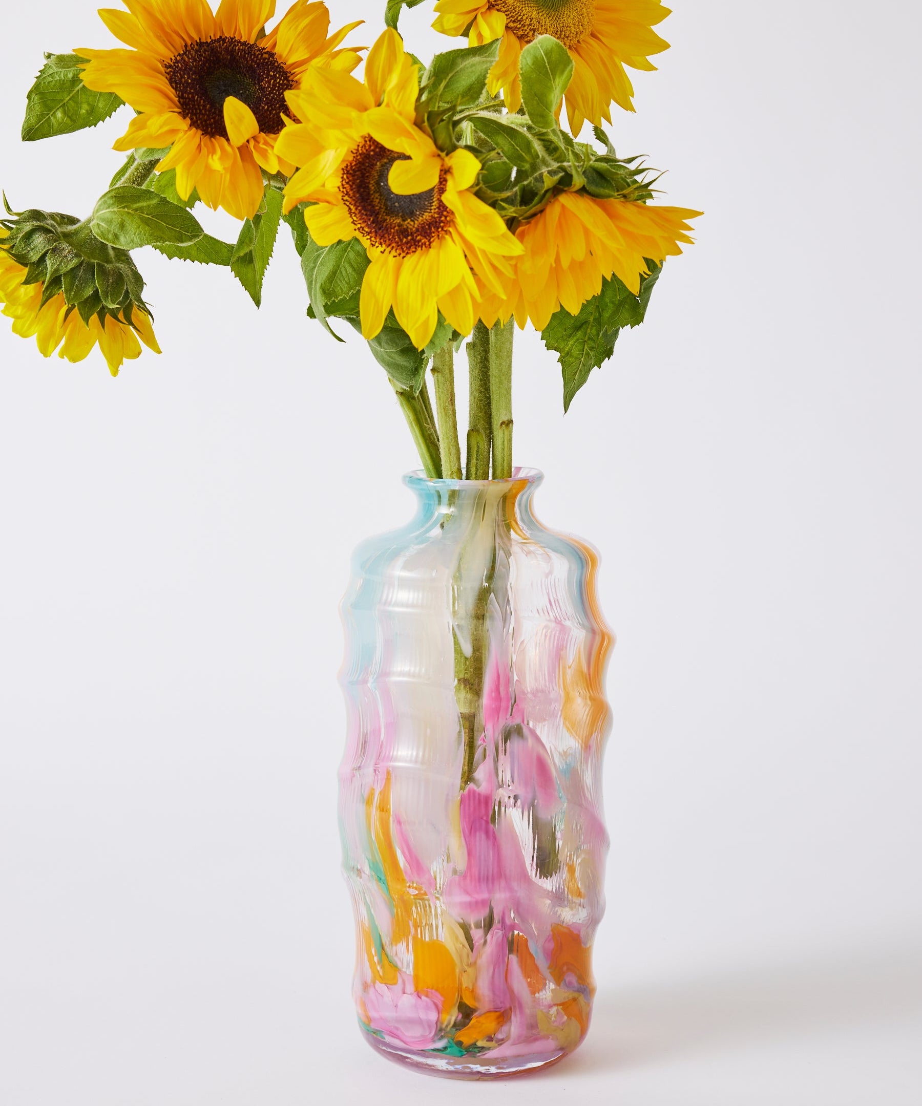 Kip & Co Swirl Sorbet tall vase with vibrant, swirling orange and pink patterns, standing upright on a white surface.