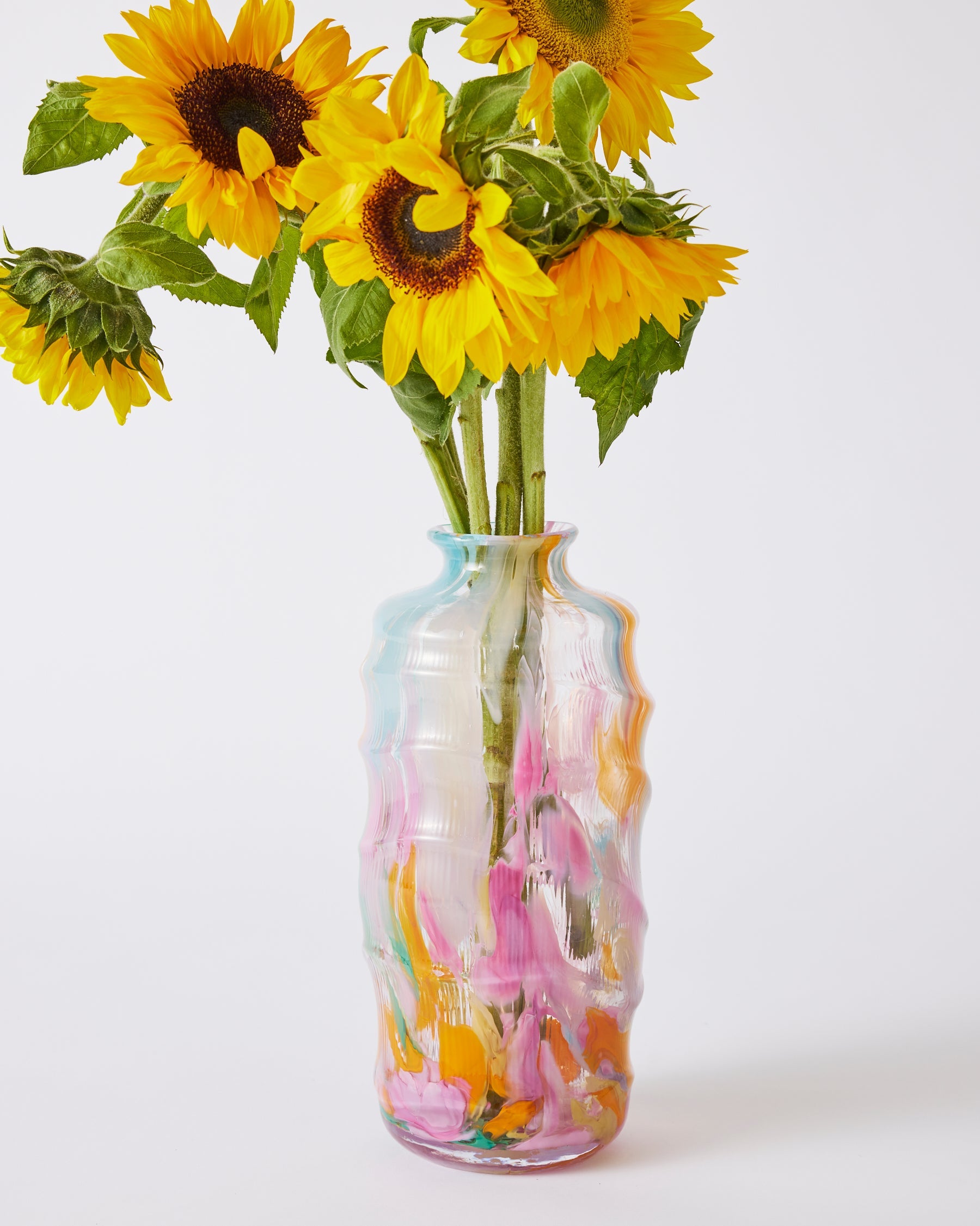 Kip & Co Swirl Sorbet tall vase with vibrant, swirling orange and pink patterns, standing upright on a white surface.