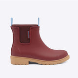 Brick red Merry People Bobbi gumboots shown from the side, featuring waterproof rubber and stylish design for rainy weather.
