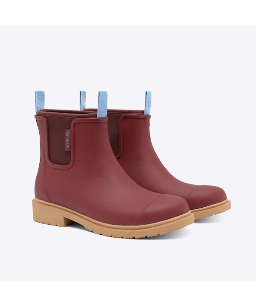 Brick red Merry People Bobbi gumboots with black sole and rounded toe, stylish waterproof footwear for rainy days.