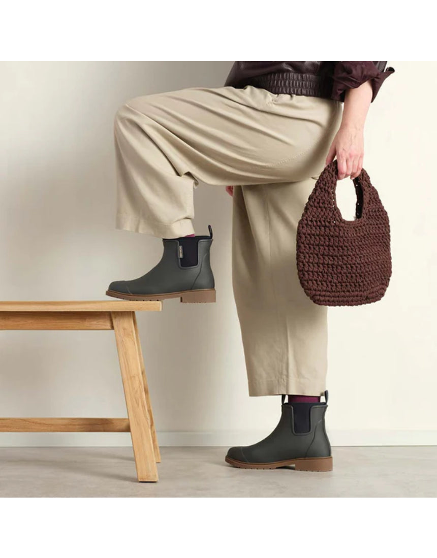 Charcoal Merry People Bobbi gumboots worn on a model, featuring waterproof rubber design and stylish ankle height.