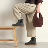 Charcoal Merry People Bobbi gumboots worn on a model, featuring waterproof rubber design and stylish ankle height.
