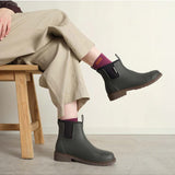 Merry People Bobbi gumboots in charcoal color worn by a model, showcasing waterproof rubber footwear for rainy weather.