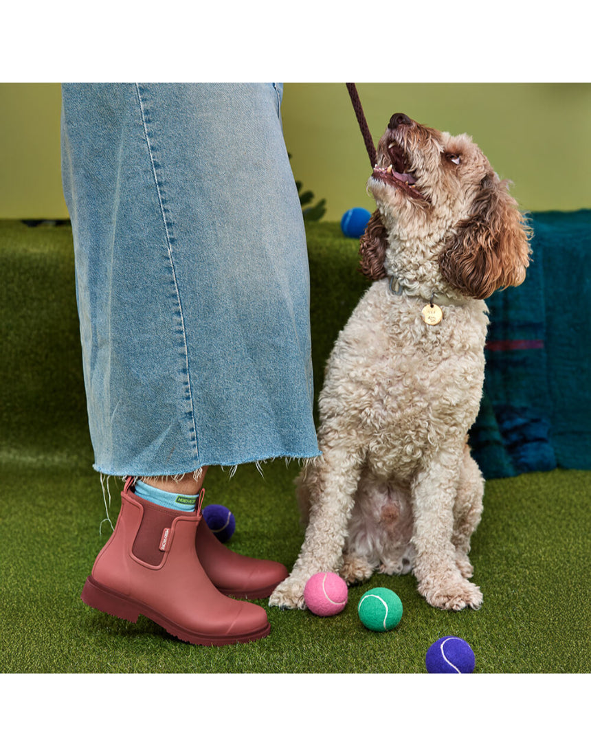 Merry People Bobbi Gumboots in clay color, stylish waterproof rubber boots on a person standing outdoors.