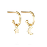 Linda Tahija star and moon charm earrings featuring gold-tone celestial pendants on delicate hooks.
