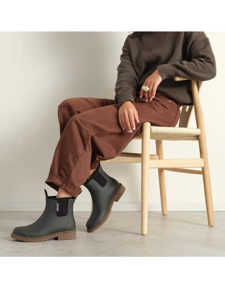Merry People Bobbi gumboots in charcoal color worn by a model, showcasing waterproof footwear with a stylish, casual design.