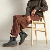 Merry People Bobbi gumboots in charcoal color worn by a model, showcasing waterproof footwear with a stylish, casual design.