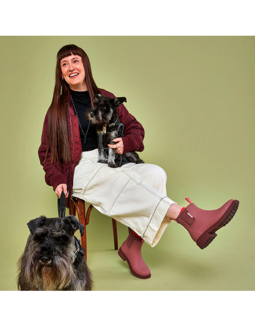 Merry People Bobbi Gumboots in clay color, stylish waterproof rubber boots for rainy weather, shown outdoors with greenery.