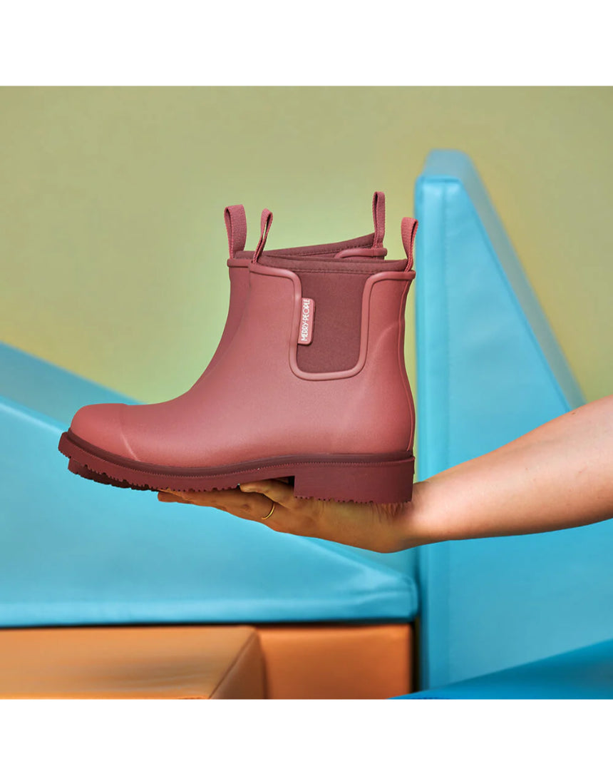 Merry People Bobbi Gumboot in clay color, stylish waterproof rubber boots for outdoor wear, shown in a lifestyle setting.