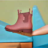 Merry People Bobbi Gumboot in clay color, stylish waterproof rubber boots for outdoor wear, shown in a lifestyle setting.