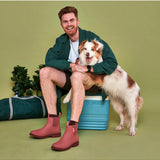 Merry People Bobbi gumboots in clay color, stylish waterproof rubber boots for rainy days, shown in outdoor lifestyle setting.
