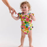 Kip & Co baby girl short sleeve frill romper with sun-themed pattern, soft fabric, and cute ruffle details.