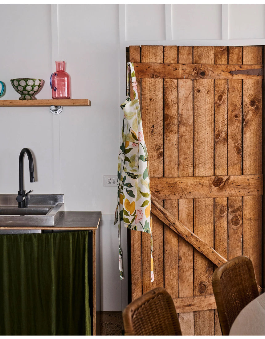 Kip & Co Wander apron displayed with its colorful, patterned fabric and adjustable neck strap, perfect for cooking or crafting.