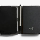 Bellroy black notebook cover open to reveal interior slots and pen holder, made from smooth leather.