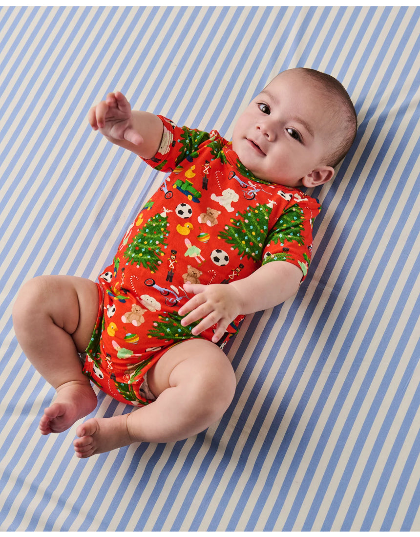 Kip & Co Christmas Toys short sleeve baby romper with colorful holiday-themed print, comfortable cotton fabric, and soft short sleeves.
