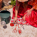 Kip & Co garden tools and gloves set featuring colorful trowel, pruning shears, and protective gardening gloves on a wooden surface.