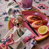 Kip & Co Pretty Pansy tablecloth featuring vibrant floral patterns on fabric for a stylish dining table.