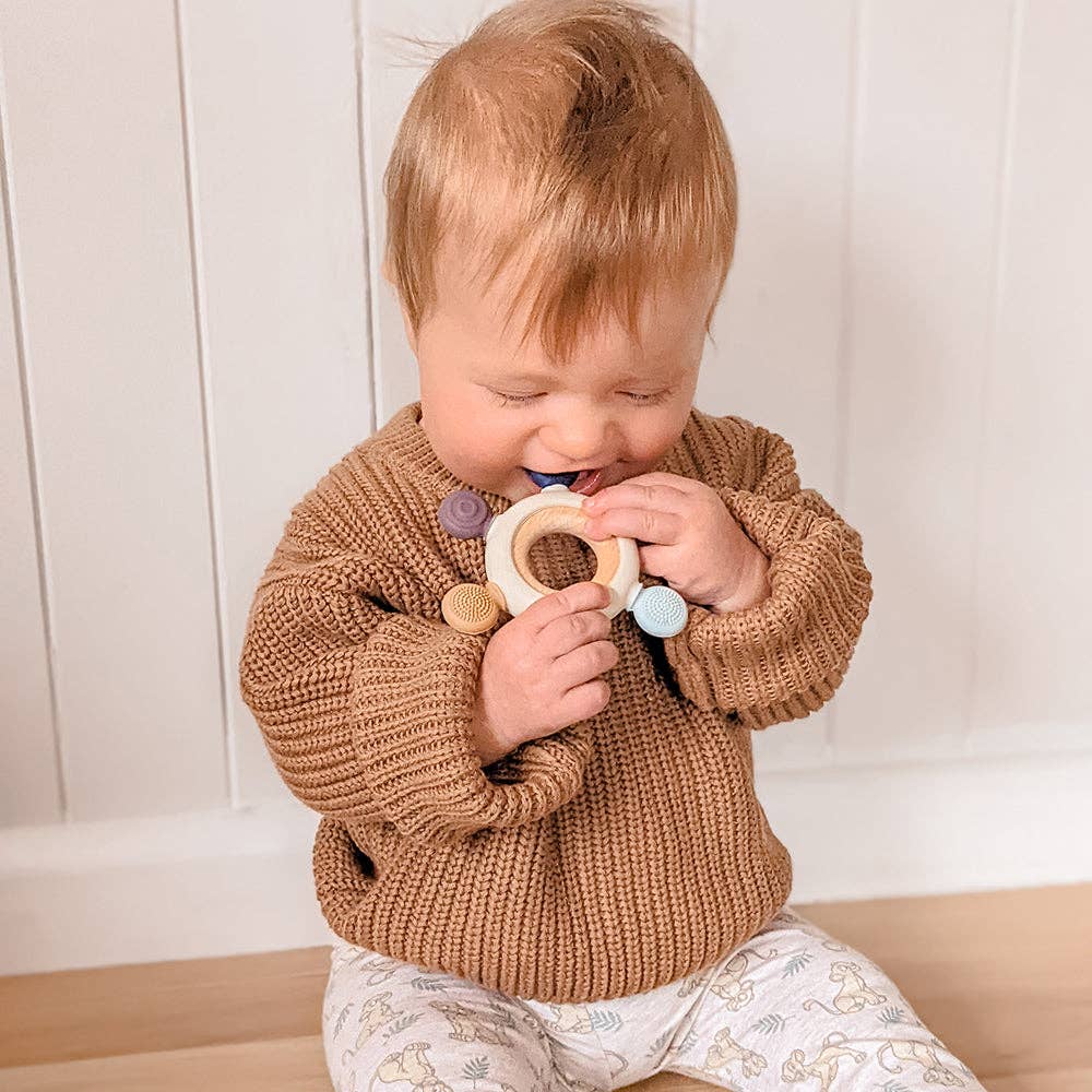 Living Textiles multi-surface teething wheel in steel blue with textured surface and colorful beads for soothing teething relief.