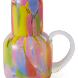 Kip & Co Festiva glass and carafe set with colorful floral patterns, clear glass design, and elegant shapes for serving beverages.