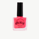 Kids nail polish by Oh Flossy in vibrant pink color, displayed in a clear bottle with a white cap.