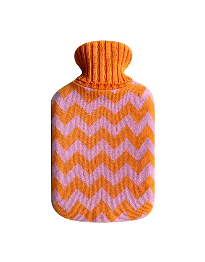 Casa Rolio hot water bottle with orange tangerine cover, soft fabric and flexible rubber body for soothing warmth.