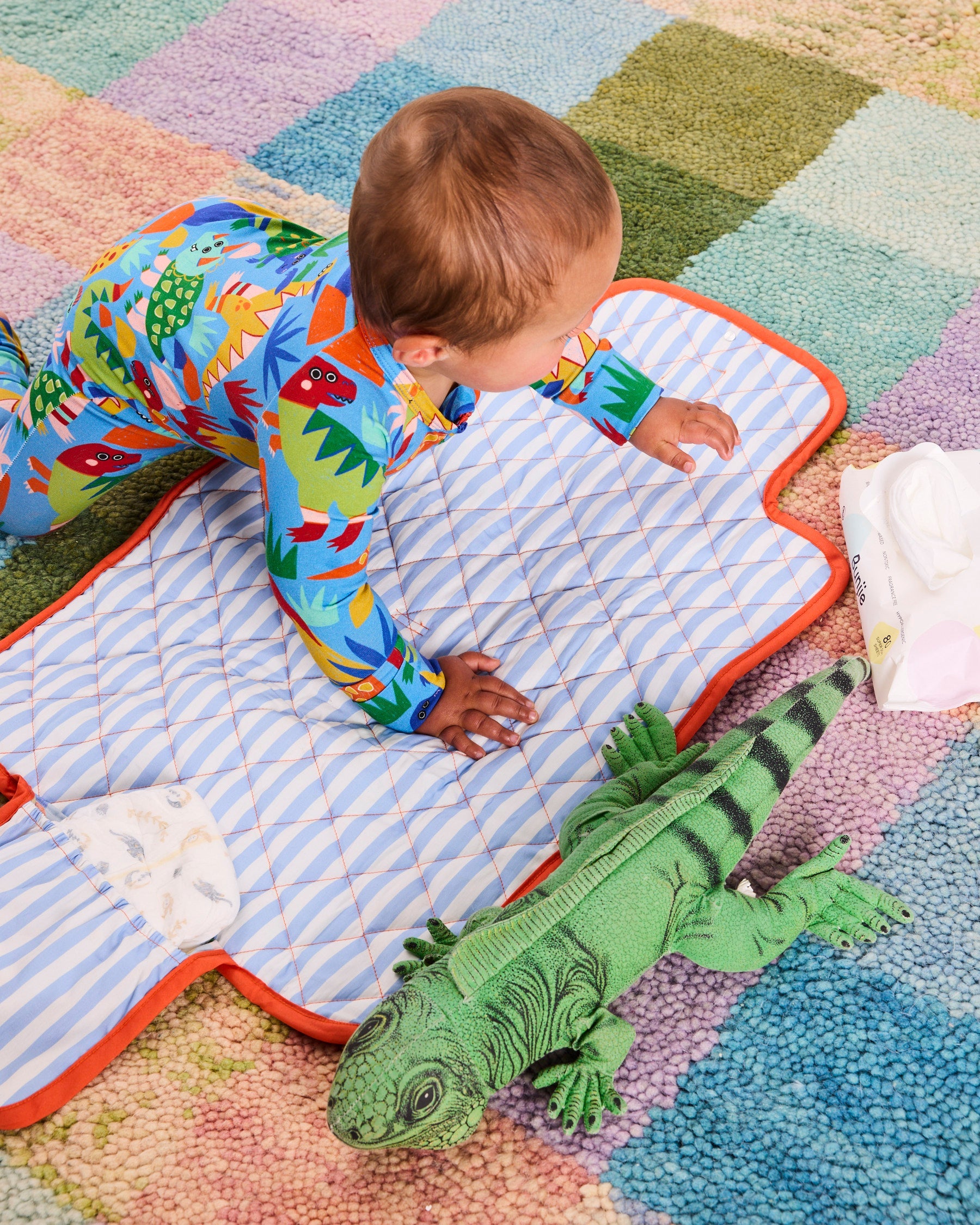 Kip & Co Dinosaur Roar organic baby romper with long sleeves and zip closure, featuring colorful dinosaur print on soft fabric.