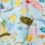 Kip & Co Reef Life cotton baby bib with ocean-inspired print, soft fabric, and adjustable neck closure for comfortable feeding.