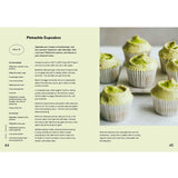 Open baking book by Brumby Sunstate featuring pistachio recipes and detailed baking tips on a wooden table.