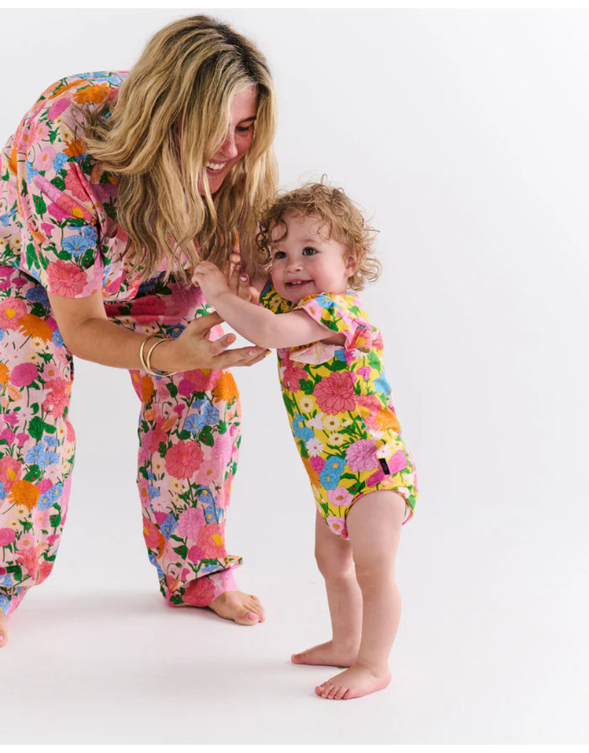 Kip & Co baby clothing Follow the Sun short sleeve frill romper with colorful floral print and ruffled details.