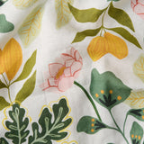 Kip & Co Wander apron with colorful, patterned fabric, tied waist, and adjustable neck strap for cooking or baking.