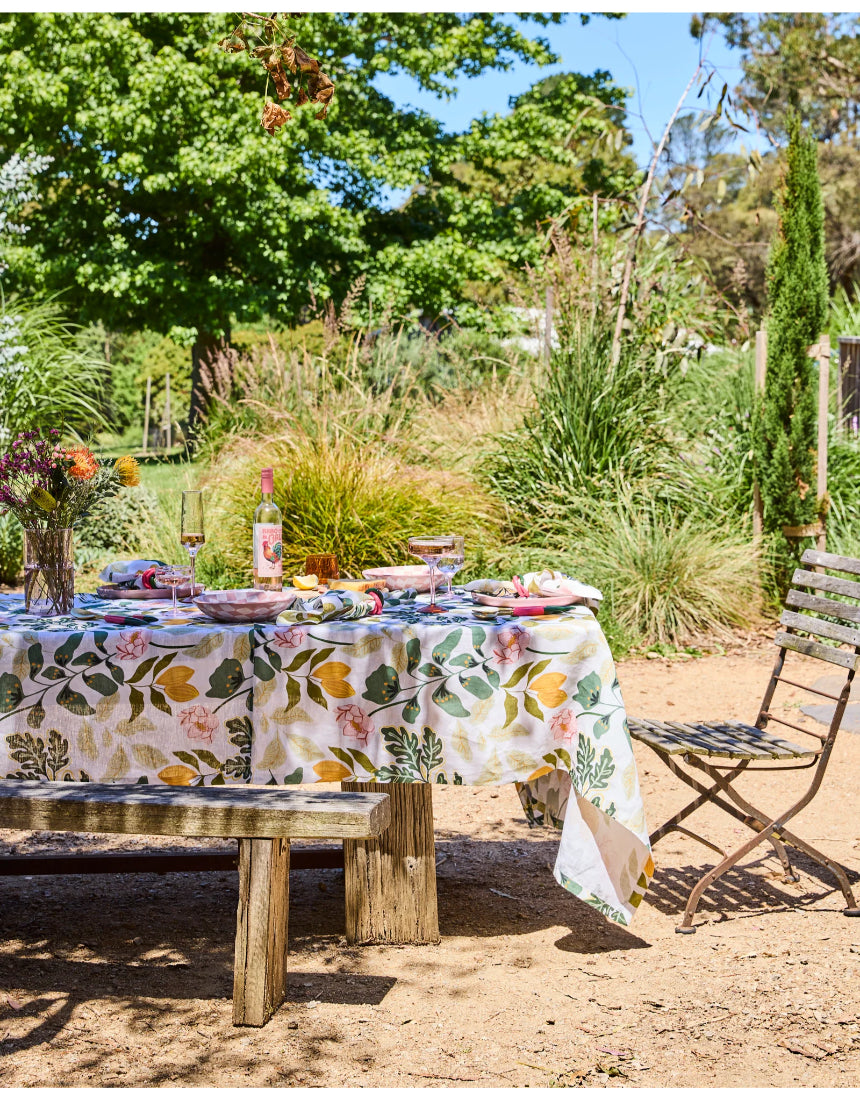 Kip & Co Wander rectangular tablecloth with colorful, patterned fabric draped over a dining table.