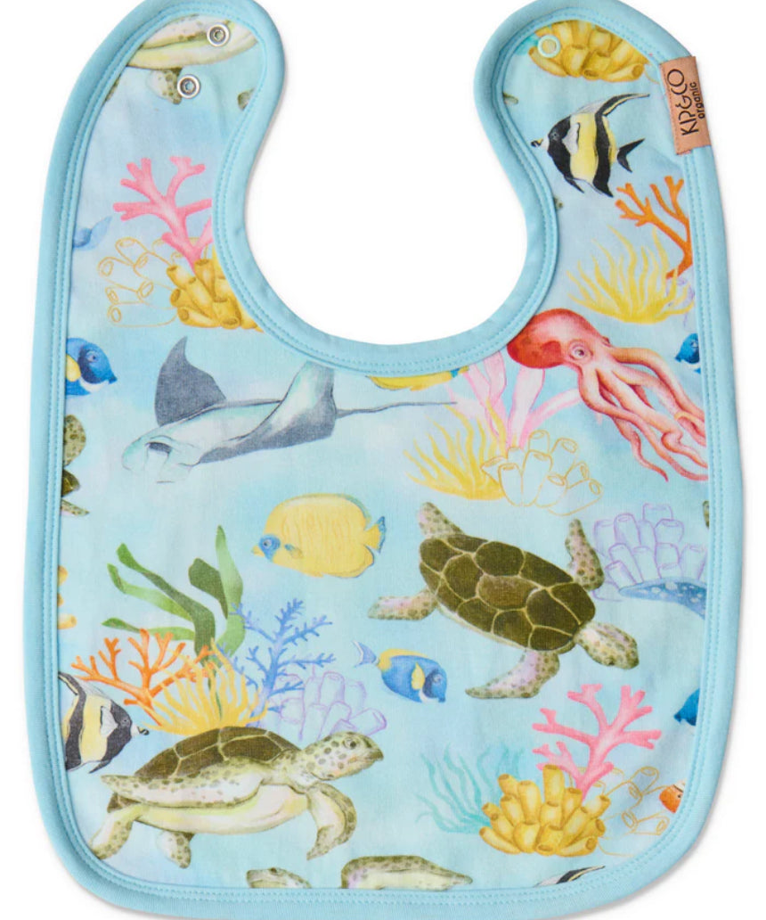 Kip & Co Reef Life cotton baby bib with colorful ocean-inspired print and adjustable neck closure.