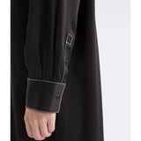 Black Elk Famke Dress displayed on a hanger, showcasing its stylish design and fabric details.