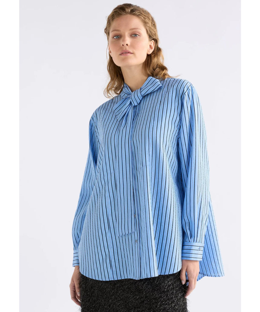Elk Hedi shirt in chambray stripe, casual men's clothing with a button-up front and long sleeves, displayed on a hanger.