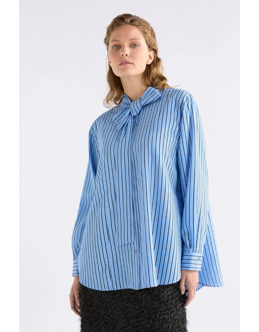 Elk Hedi shirt in chambray stripe, casual men's clothing with a button-up front and long sleeves, displayed on a hanger.