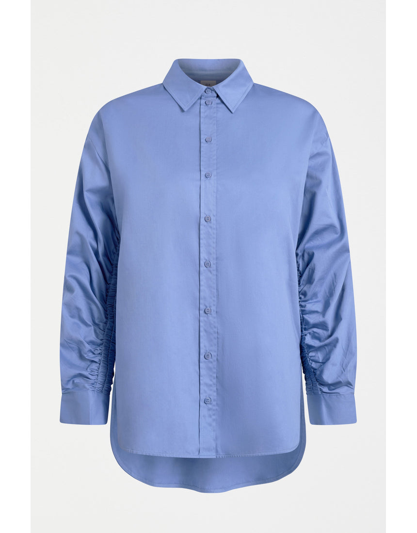 ELK The Label Sol Shirt in Dusk Blue, a stylish women's top with a relaxed fit and soft fabric, displayed on a hanger.