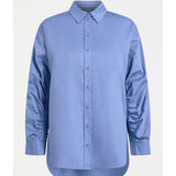 ELK The Label Sol Shirt in Dusk Blue, a stylish women's top with a relaxed fit and soft fabric, displayed on a hanger.