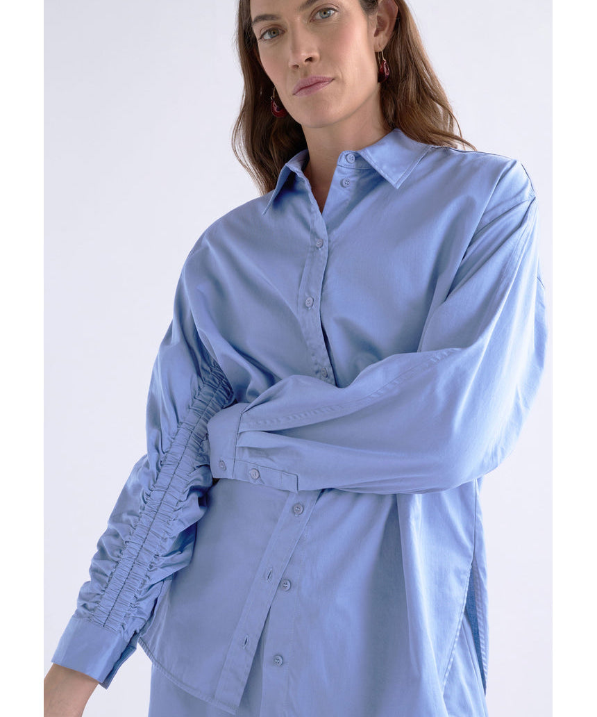 Dusk blue Elk Sol Shirt from ELK The Label, a stylish women's top with a relaxed fit and soft fabric, shown on a hanger.