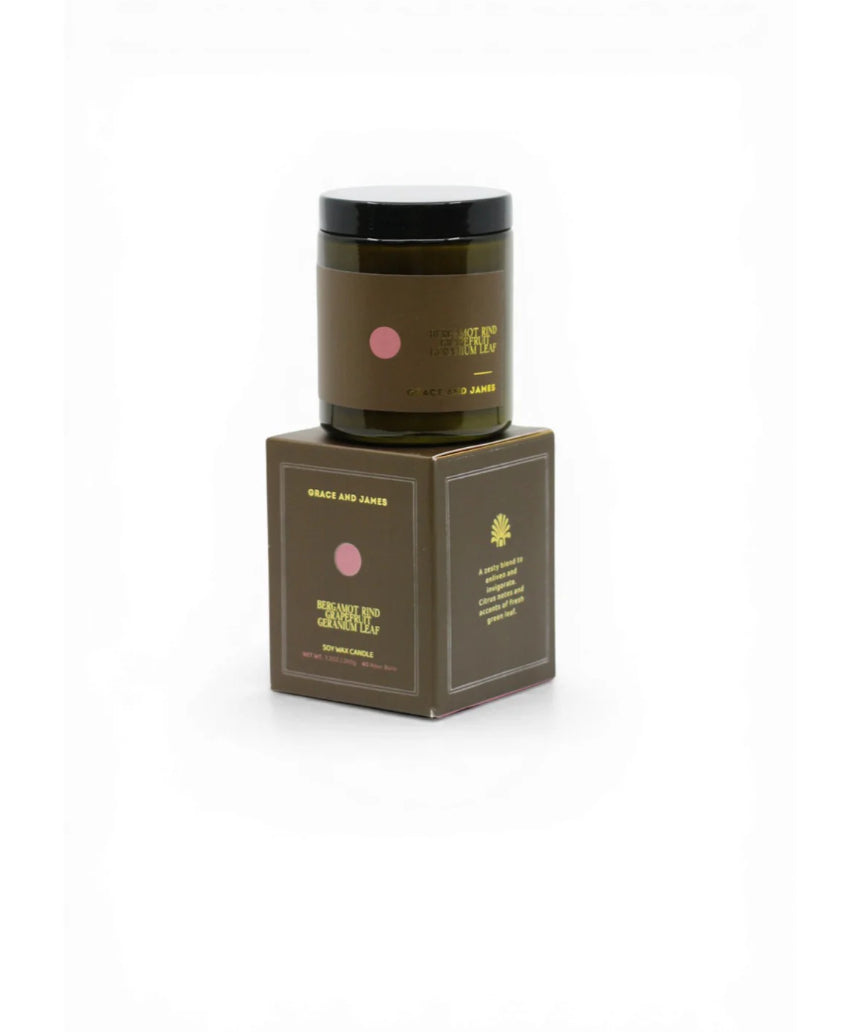 Grace and James Forager Candle with bergamot rind, grapefruit, and geranium, featuring a stylish candle holder and a lit flame.