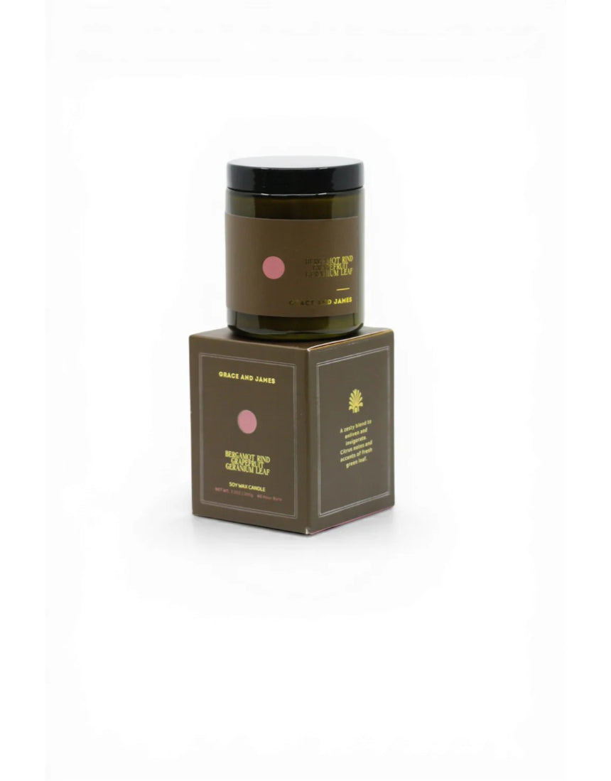 Grace and James Forager Candle with bergamot rind, grapefruit, and geranium, featuring a stylish candle holder and a lit flame.