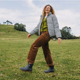 Merry People Bobbi gumboots in charcoal color, stylish waterproof rubber footwear worn outdoors in a natural setting.