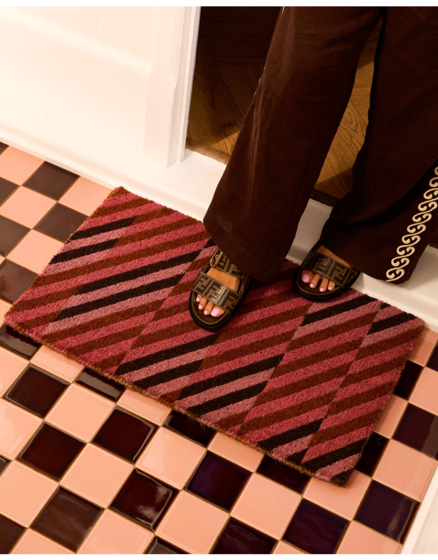 Pink patchwork door mat by Bonnie and Neil featuring vibrant, colorful patterns for welcoming entryways.