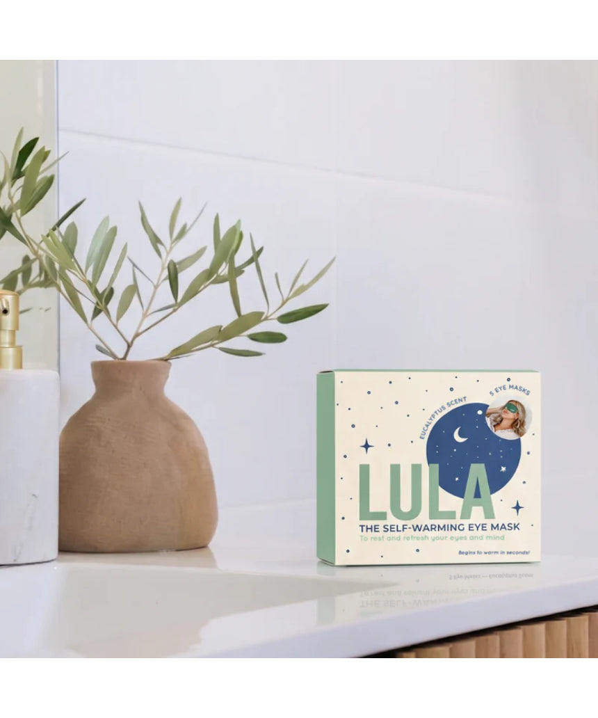Lula self-warming eye mask with eucalyptus and tea tree, shown lying flat, designed to soothe and relax tired eyes.