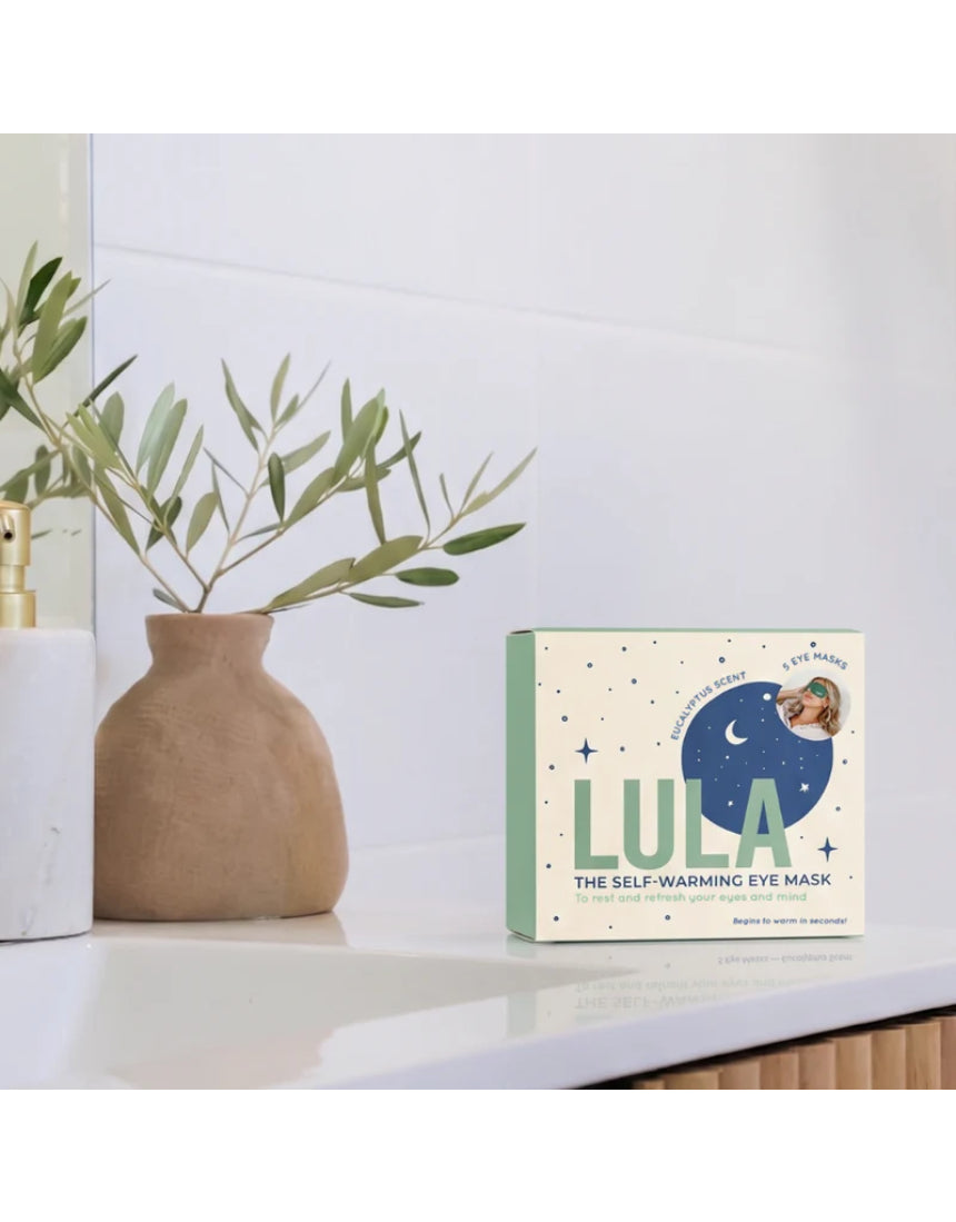 Lula self-warming eye mask with eucalyptus and tea tree, shown lying flat, designed to soothe and relax tired eyes.