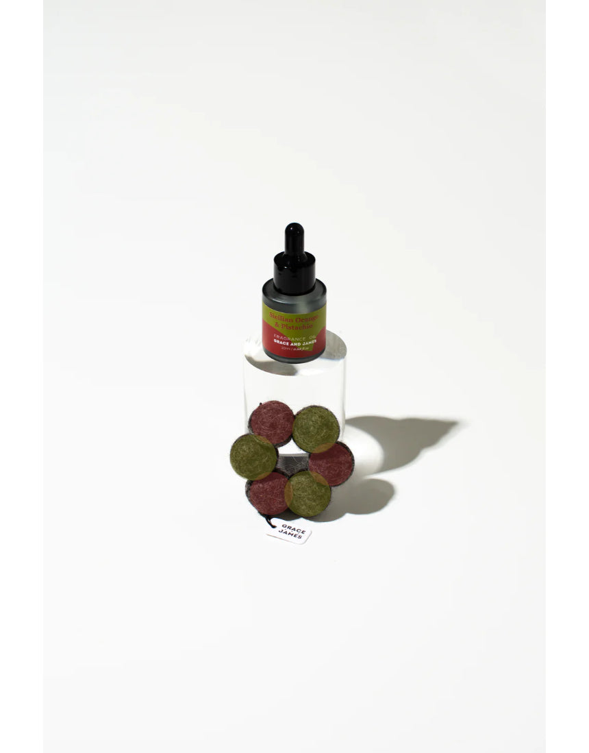 Orange and pistachio felt air freshener by Grace & James, featuring a vibrant orange and green design with a textured felt surface.