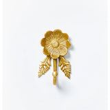 Brass Daisy Wall Hook by Bonnie and Neil, featuring a floral daisy design, mounted on a wall for decorative hanging.