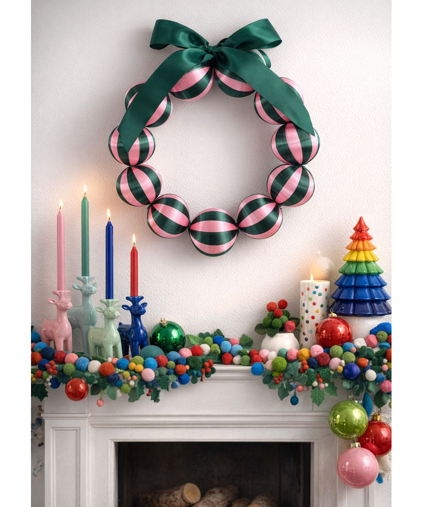 Little Fish Co silk ball Christmas wreath with green and pink decorative elements hanging on a door.