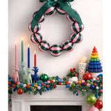 Little Fish Co silk ball Christmas wreath with green and pink decorative elements hanging on a door.