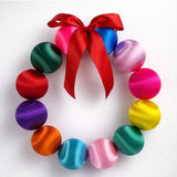 Colorful Little Fish Co silk ball Christmas wreath with vibrant multi-colored silk balls and green foliage for holiday decor.
