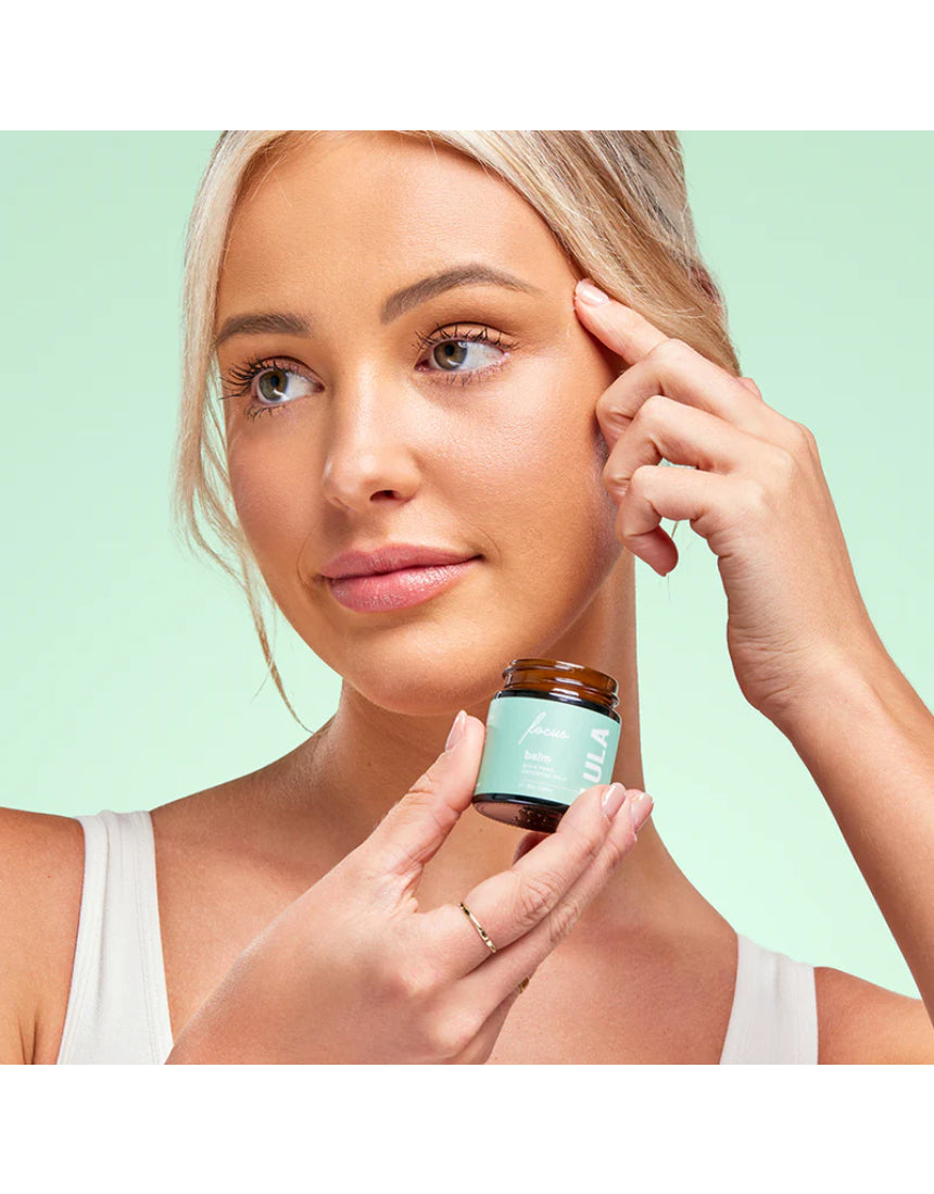Lula Focus Balm, an essential oil product, displayed in a small jar with natural ingredients visible, designed for aromatherapy.